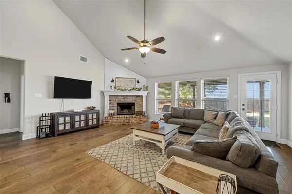 a living room with furniture a flat screen tv and a fireplace