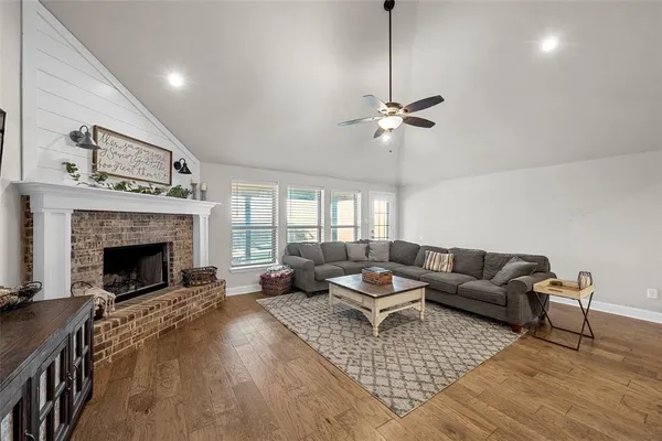 a living room with furniture a fireplace and a chandelier
