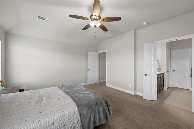 a bedroom with a large bed and a ceiling fan
