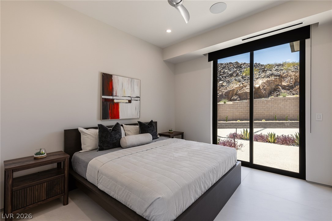 563 Grand Rim Drive Henderson, NV 89012 - Photo 36 of 70 Floor-to-ceiling glass sliders reveal dramatic mountain views from this contemporary sleeping sanctuary located off the attached casita.