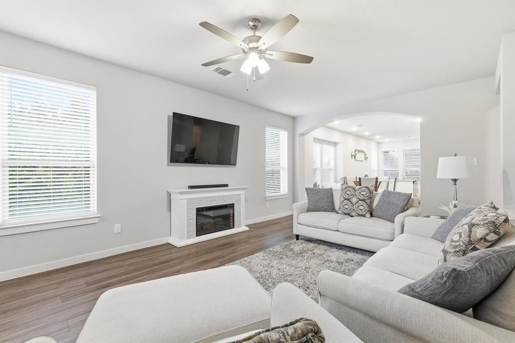 5582 Yarborough Drive Forney, TX 75126 - Photo 5 of 29 a living room with furniture a fireplace and a flat screen tv