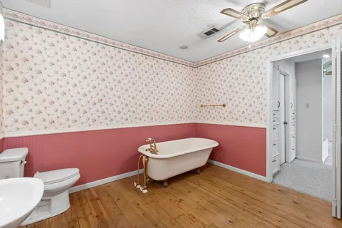 a bathroom with a granite countertop toilet and a sink