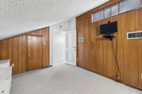 a view of a livingroom with wooden floor and a flat screen tv