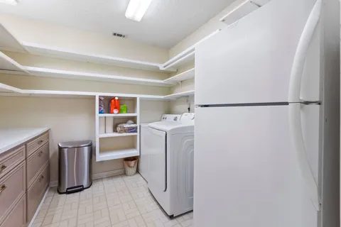 a utility room with cabinets washer and dryer