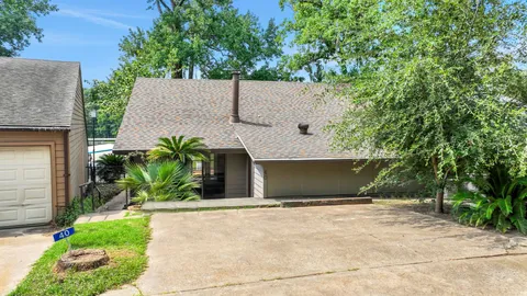 a backyard of a house with potted plants and large tree