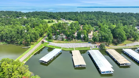 a view of a swimming pool with a yard and large trees