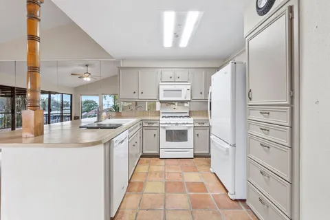 a kitchen with white cabinets and white appliances