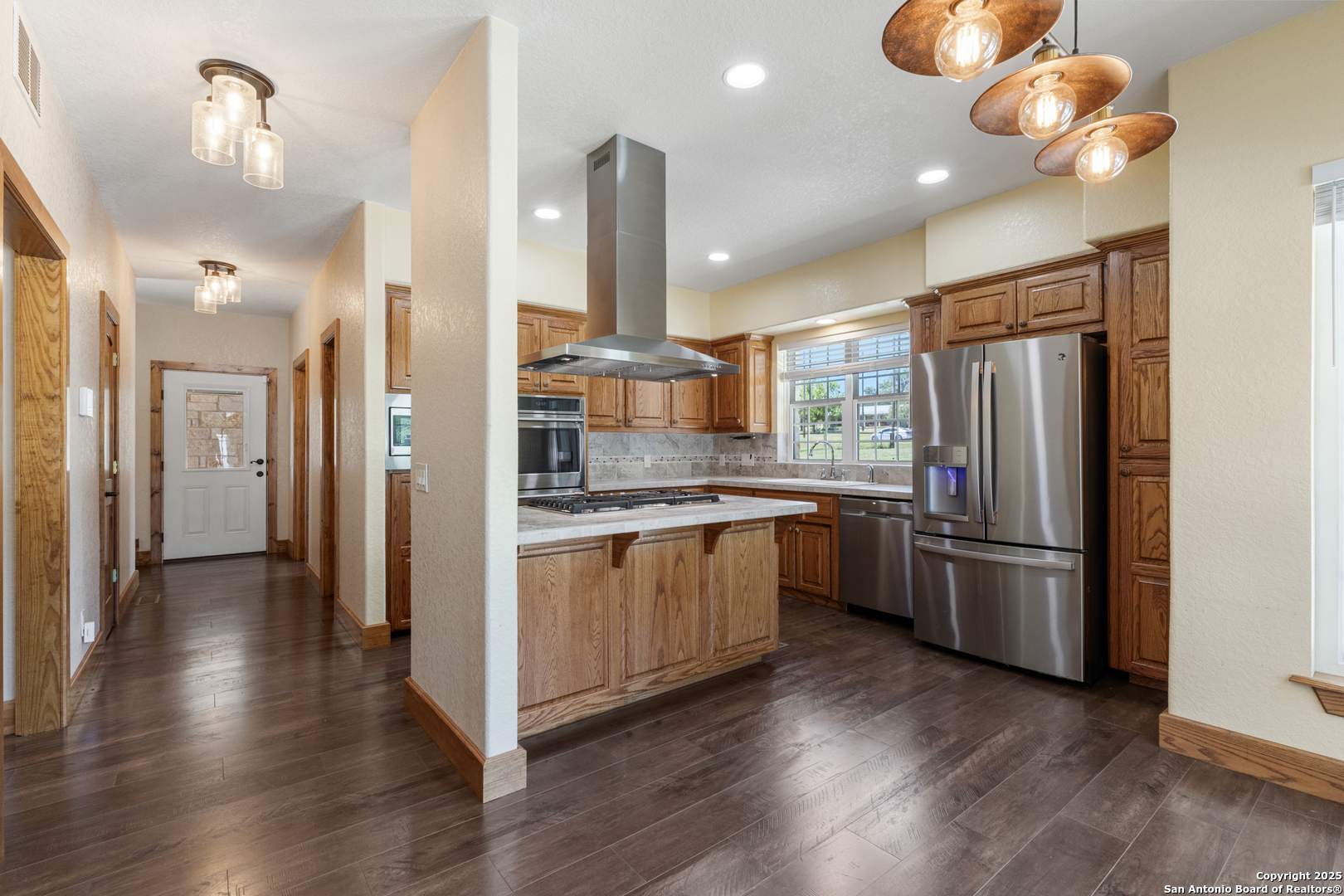 7040 Old Spring Branch Road Spring Branch, TX 78070 - Photo 11 of 43 a kitchen with refrigerator a sink and wooden floor