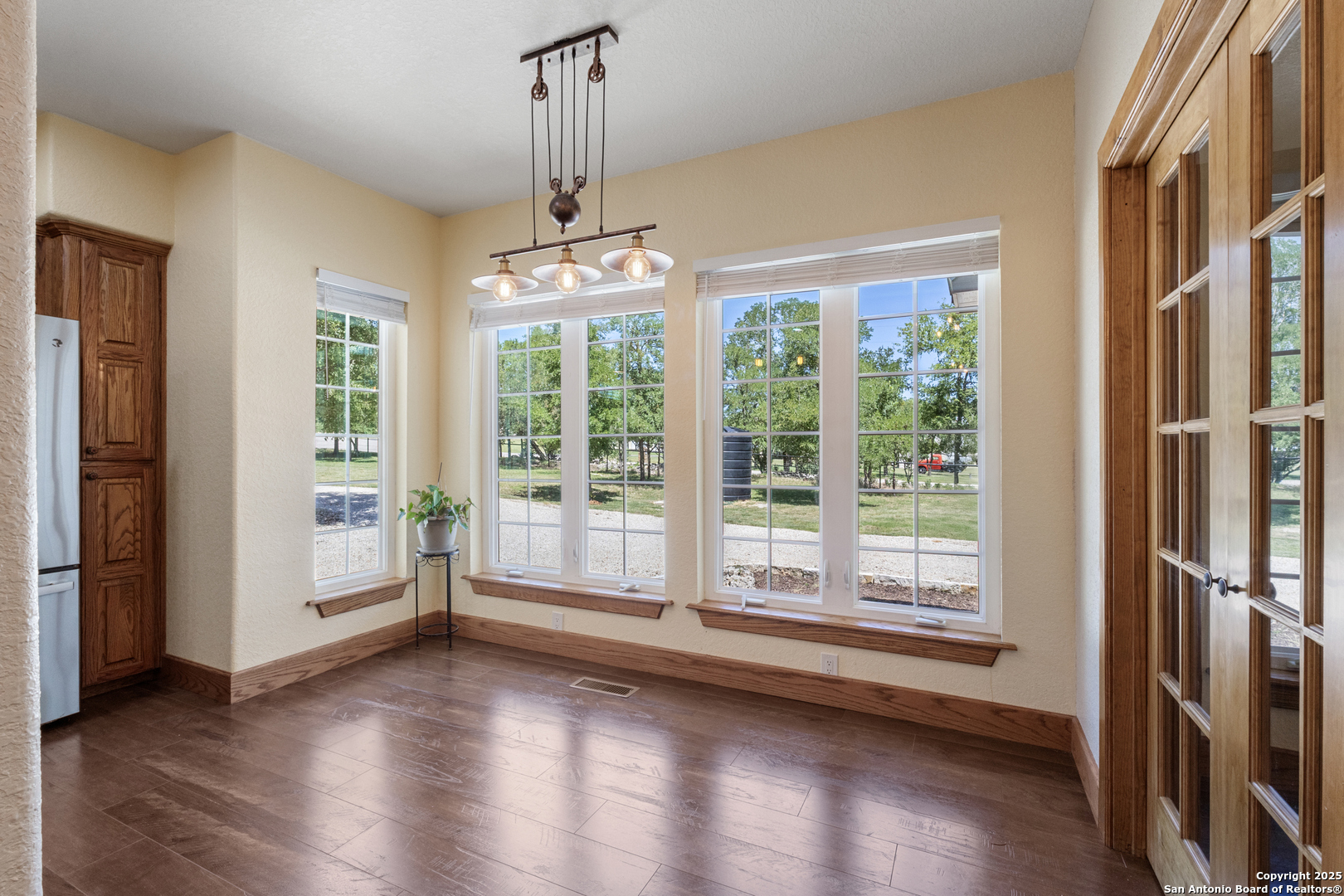 7040 Old Spring Branch Road Spring Branch, TX 78070 - Photo 17 of 43 a view of an empty room with a window and wooden floor