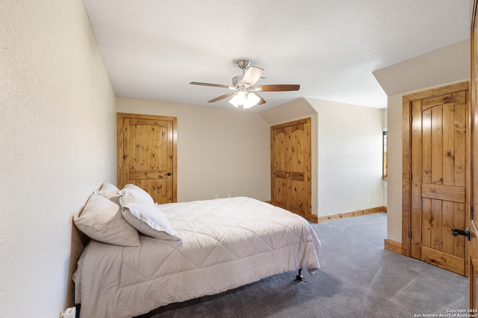 7040 Old Spring Branch Road Spring Branch, TX 78070 - Photo 25 of 43 a bedroom with a bed and a chandelier