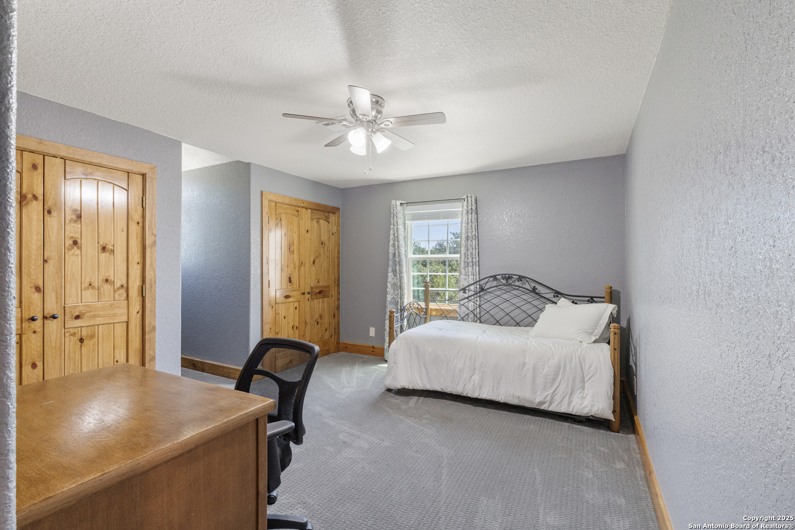 7040 Old Spring Branch Road Spring Branch, TX 78070 - Photo 27 of 43 a bedroom with a bed and a chandelier