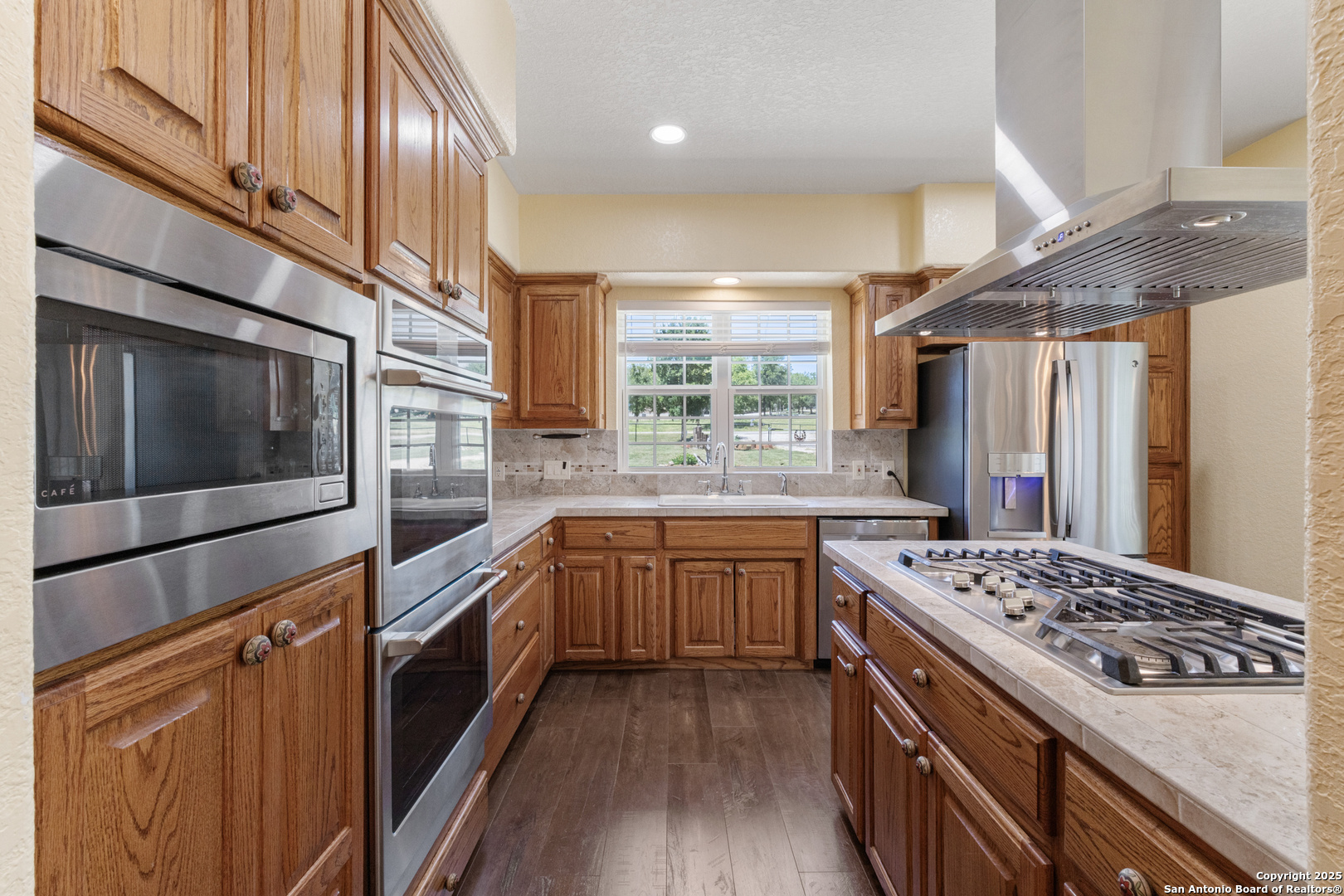 7040 Old Spring Branch Road Spring Branch, TX 78070 - Photo 8 of 43 a kitchen with stainless steel appliances kitchen island granite countertop a stove a sink dishwasher and a refrigerator