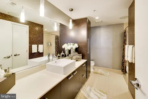 a spacious bathroom with a sink double vanity granite and a mirror