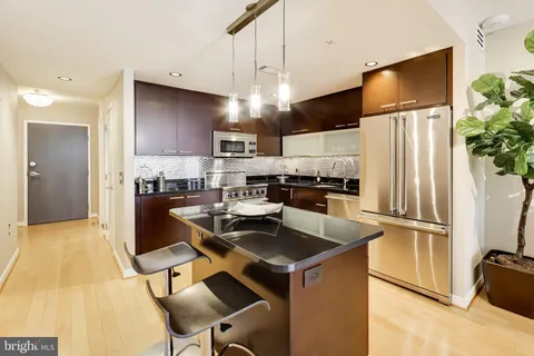 a kitchen with stainless steel appliances granite countertop a refrigerator a stove a sink dishwasher and a refrigerator