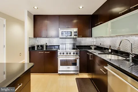 a kitchen with stainless steel appliances granite countertop a stove and a sink