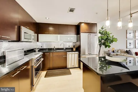a kitchen with a sink refrigerator and microwave