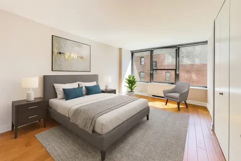 a bedroom with a bed and a lamp on dresser