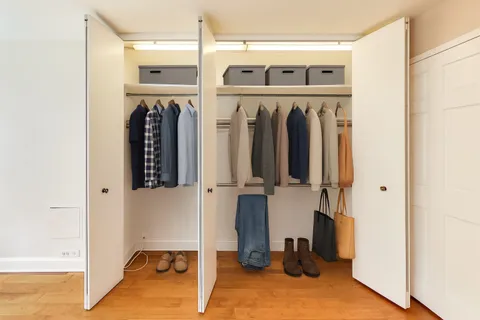 a view of walk in closet with clothes and shoes