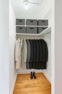 a view of walk in closet with clothes and shoes