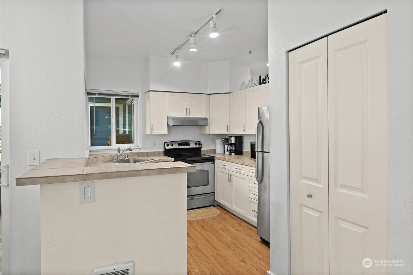 3915 243rd Place Southeast, Unit K103 Bothell, WA 98021 - Photo 11 of 36 a kitchen with a sink a refrigerator and cabinets