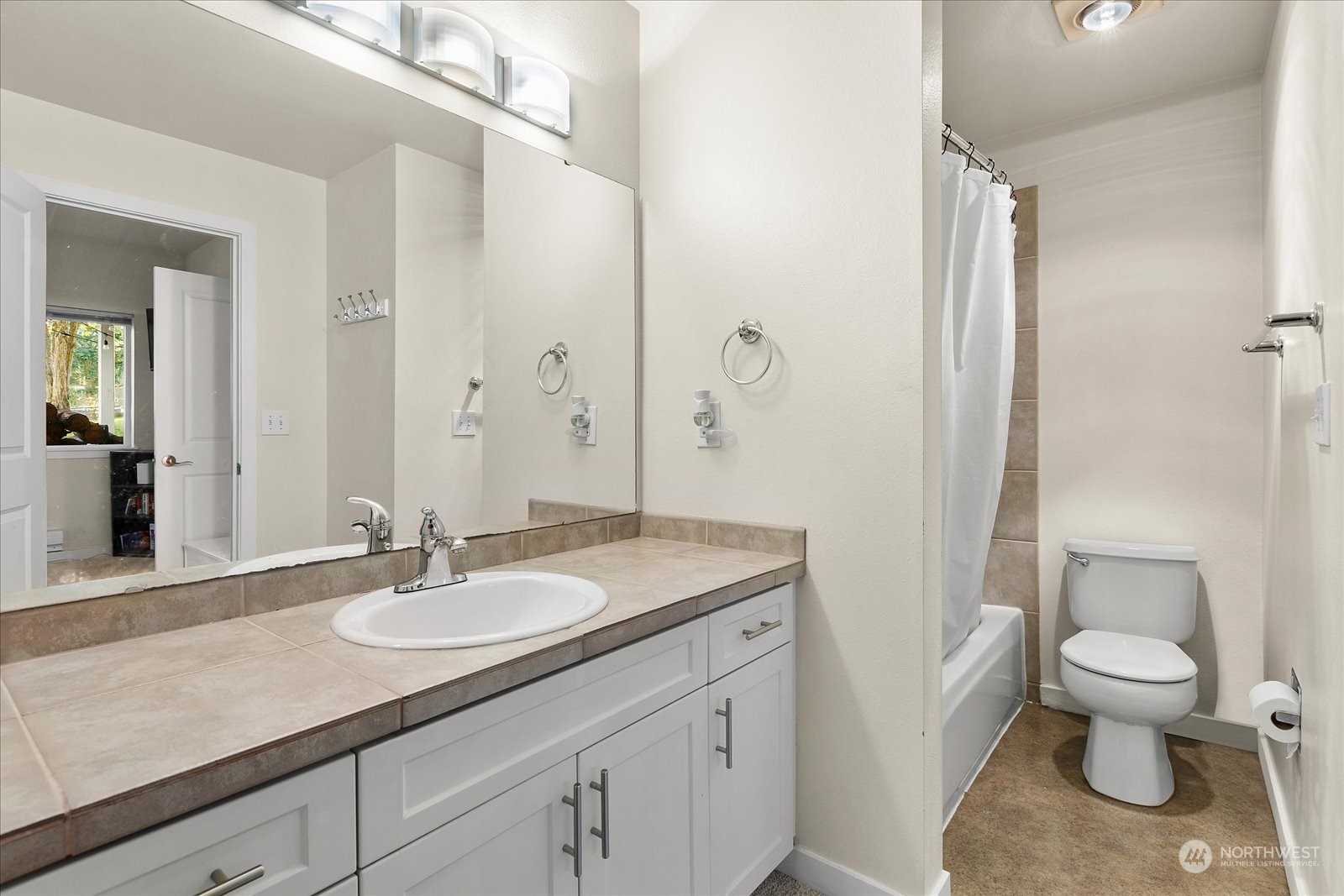 3915 243rd Place Southeast, Unit K103 Bothell, WA 98021 - Photo 14 of 36 a bathroom with a granite countertop sink a toilet and a mirror