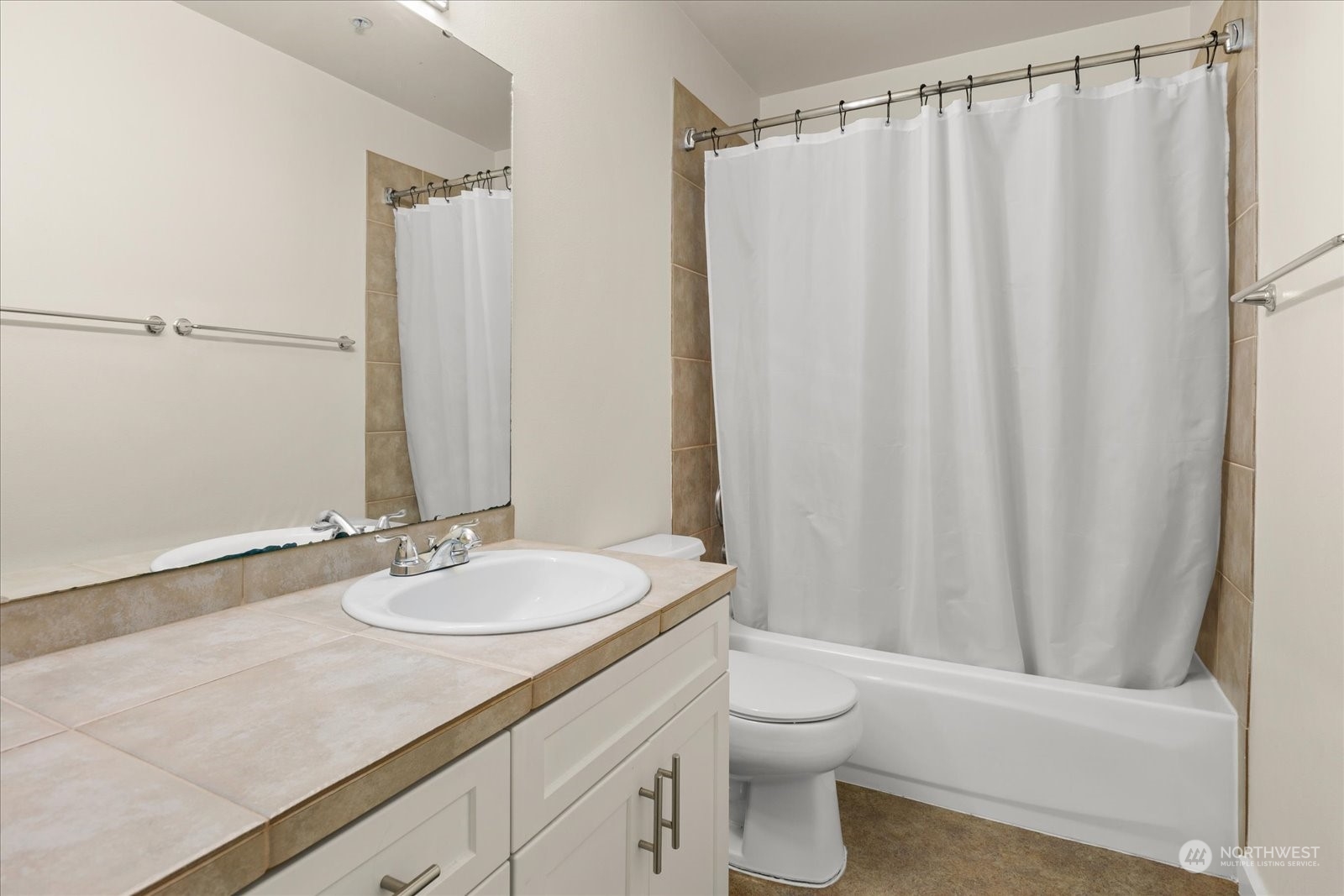 3915 243rd Place Southeast, Unit K103 Bothell, WA 98021 - Photo 18 of 36 a bathroom with a granite countertop sink toilet and a mirror