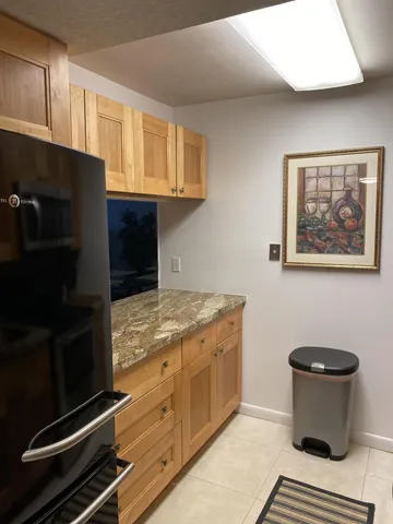 a kitchen with granite countertop a stove and a refrigerator