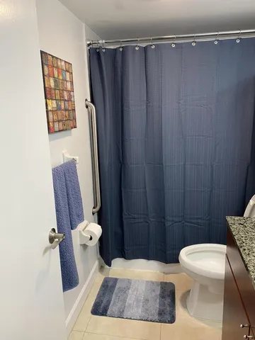a bathroom with a toilet and a shower curtain