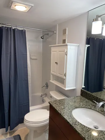 a bathroom with a granite countertop sink toilet and shower