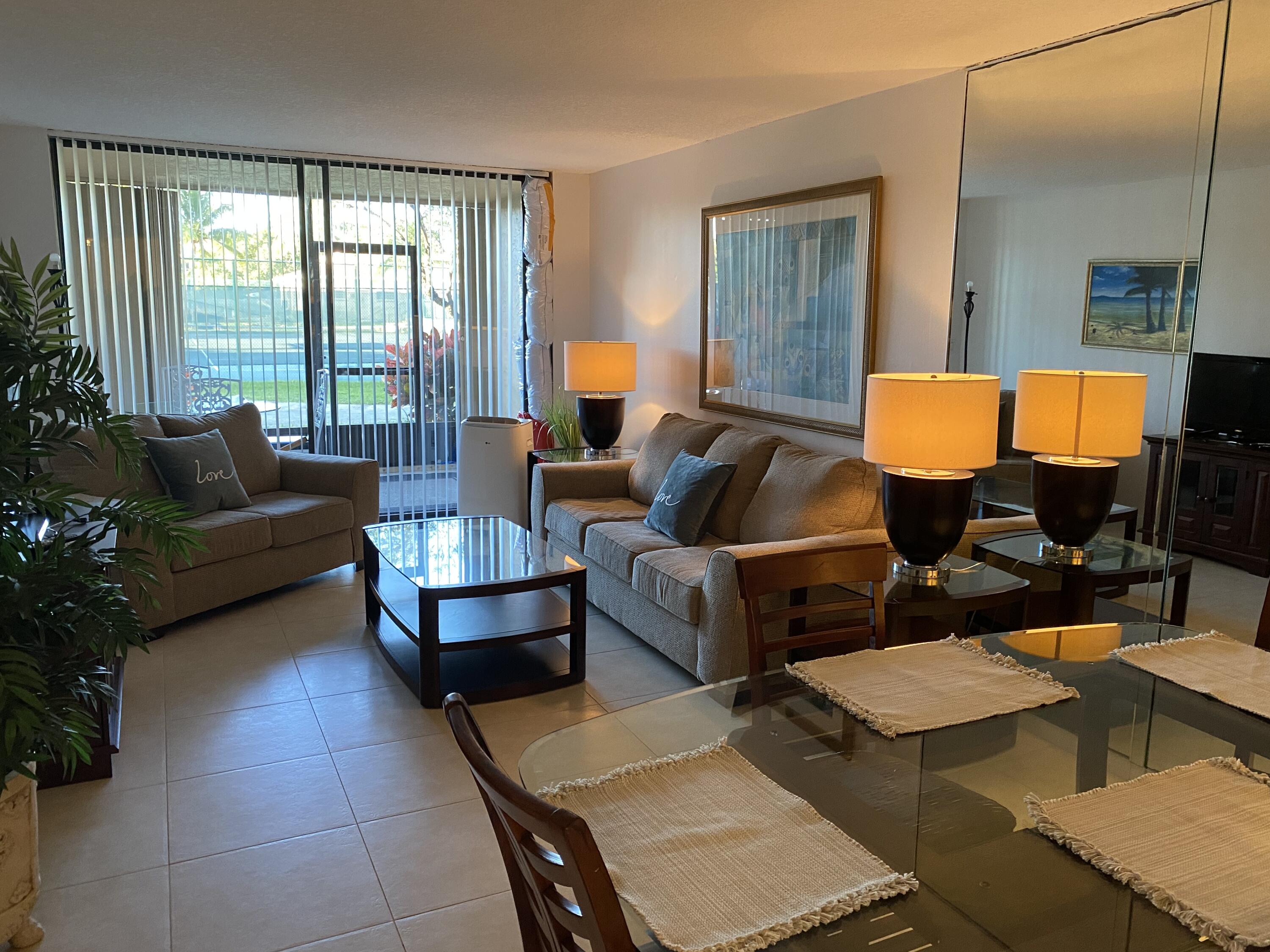 755 Dotterel Road, Unit 1108 Delray Beach, FL 33444 - Photo 6 of 28 a living room with furniture and a lamp