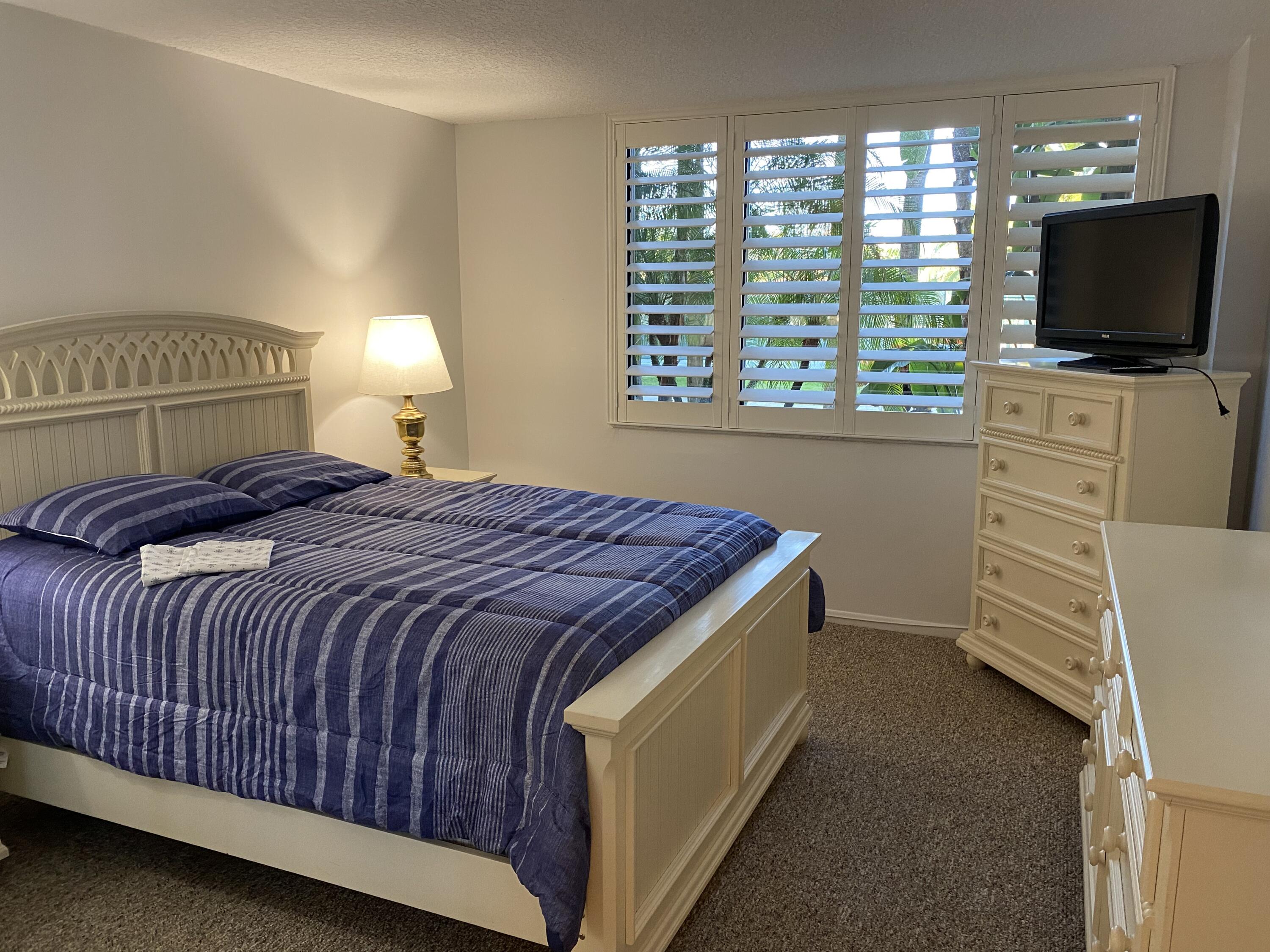 755 Dotterel Road, Unit 1108 Delray Beach, FL 33444 - Photo 9 of 28 a bedroom with a bed and a flat tv screen on dresser