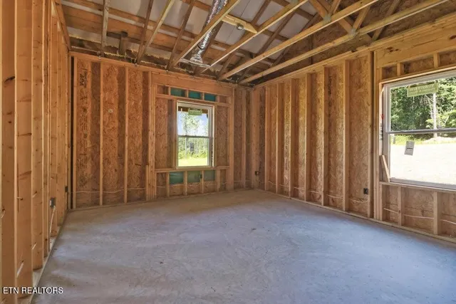 a view of a lush green forest with trees and some houses