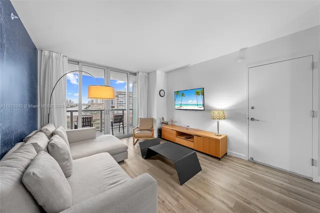 a living room with furniture and a floor to ceiling window