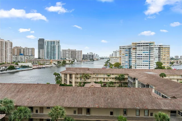 a living room with stainless steel appliances furniture and a flat screen tv