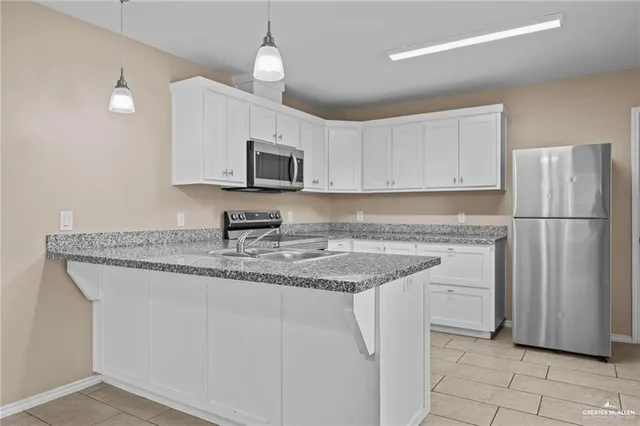 a kitchen with stainless steel appliances granite countertop a refrigerator sink and microwave