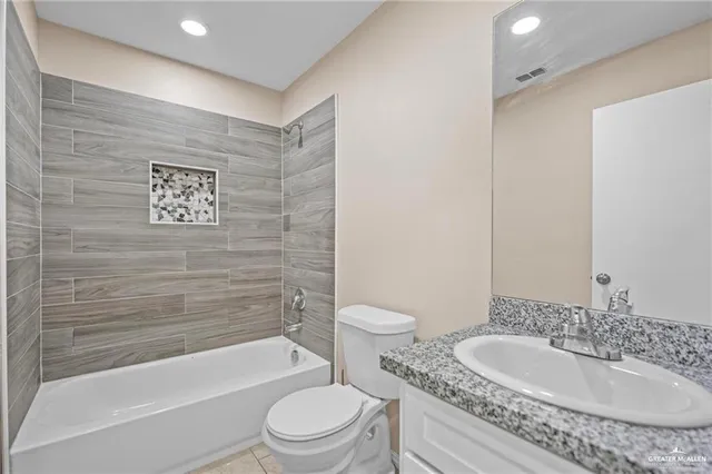 a bathroom with a granite countertop toilet a sink and bathtub