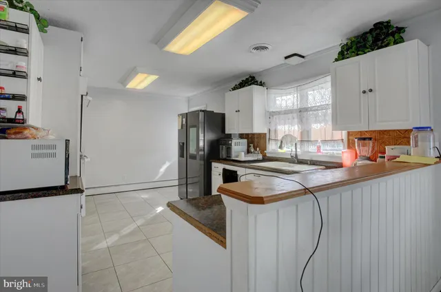 a kitchen with stainless steel appliances kitchen island granite countertop a refrigerator and a stove top oven