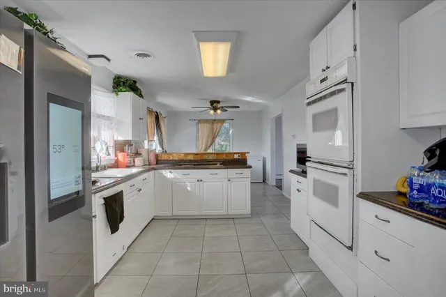a kitchen with white cabinets and appliances