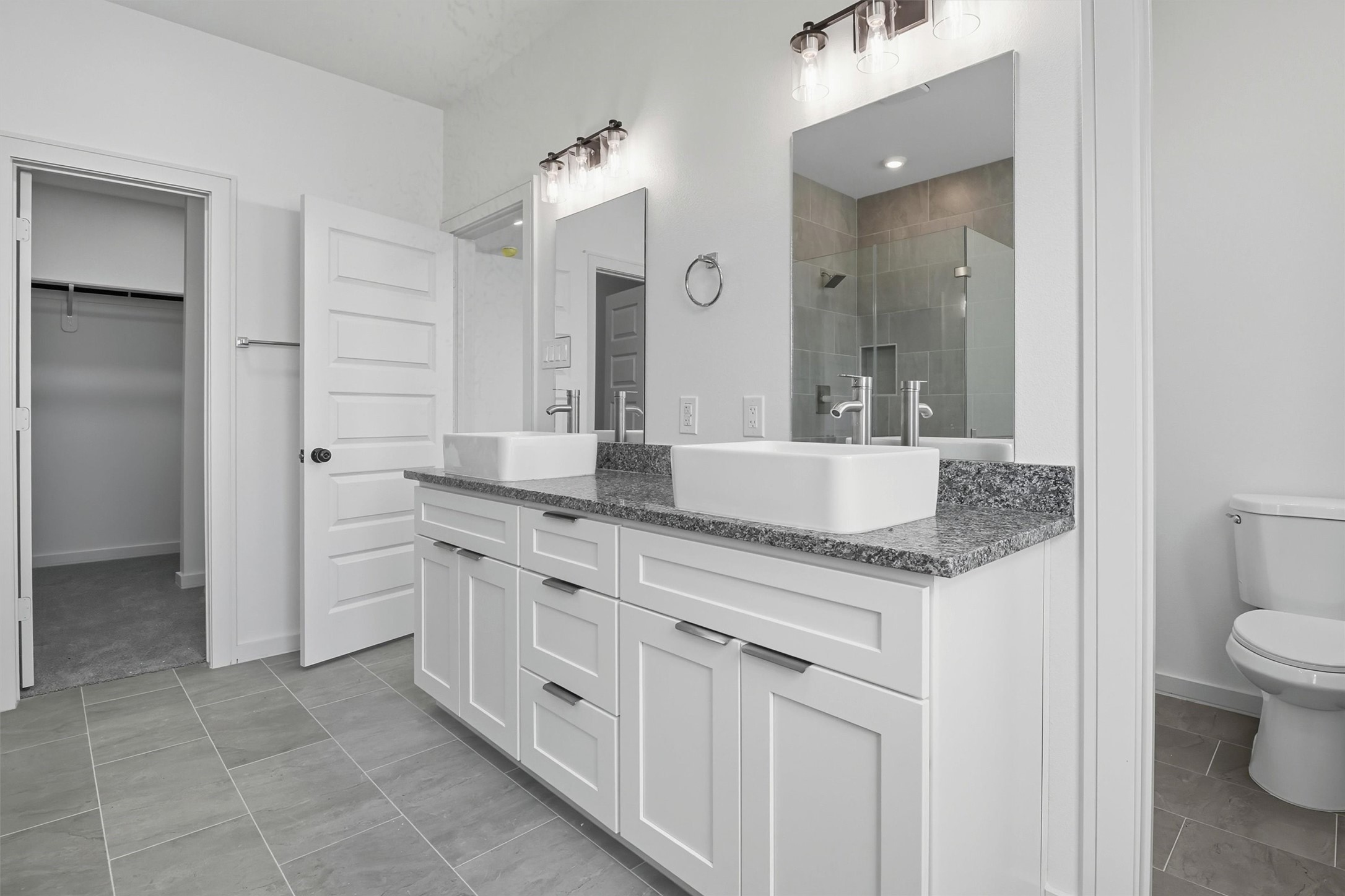 2927 El Fenice Lane Houston, TX 77057 - Photo 36 of 47 a spacious bathroom with a granite countertop sink and a mirror