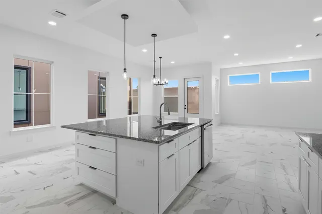 a kitchen with stainless steel appliances granite countertop a sink a stove and a refrigerator