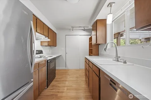 a kitchen with stainless steel appliances granite countertop a sink stove and refrigerator