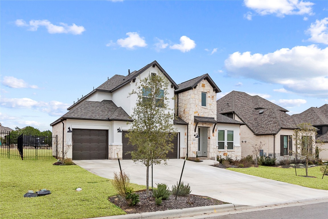 682 Two Creeks Lane Austin, TX 78737 - Photo 1 of 33 a front view of a house with a yard and garage