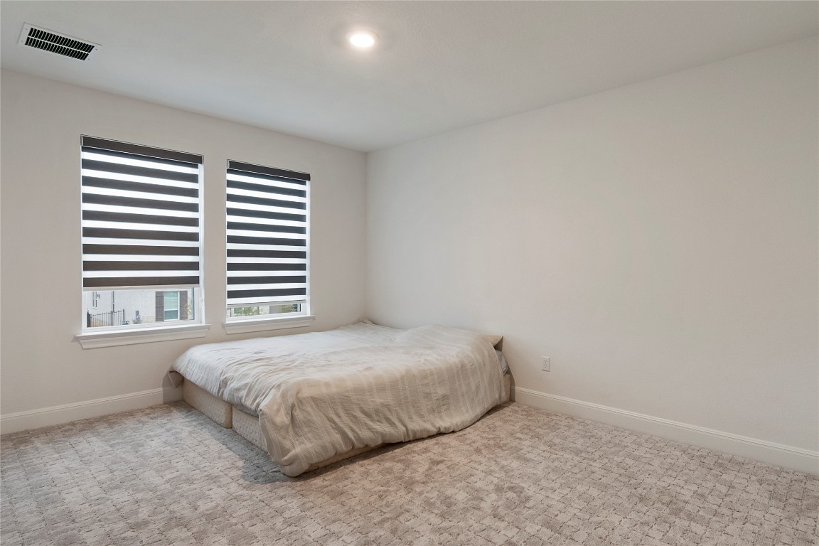 682 Two Creeks Lane Austin, TX 78737 - Photo 23 of 33 a bedroom with a bed and a window