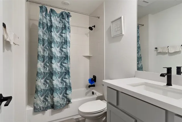 a bathroom with a sink a toilet and a shower curtain