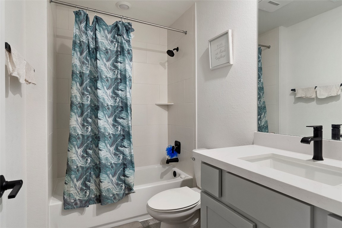 682 Two Creeks Lane Austin, TX 78737 - Photo 24 of 33 a bathroom with a sink a toilet and a shower curtain