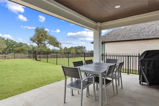 a view of a patio with a table chairs and a backyard