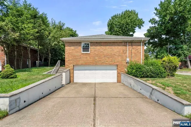 a view of backyard with large trees and wooden fence