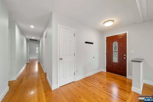 a view of a hallway with wooden floor and closet