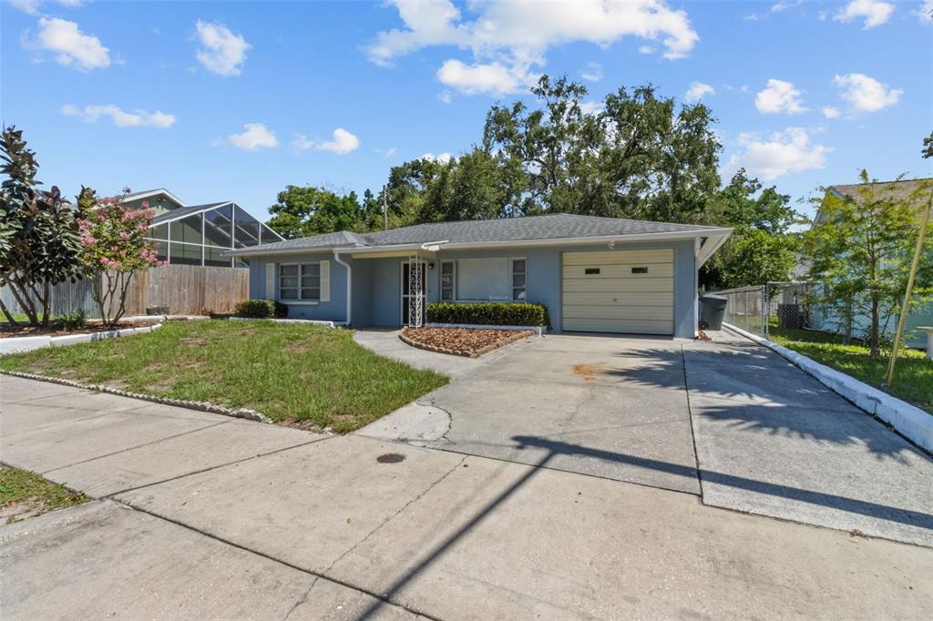 512 Richmond Street Dunedin, FL 34698 - Photo 1 of 37 a front view of a house with a yard and potted plants