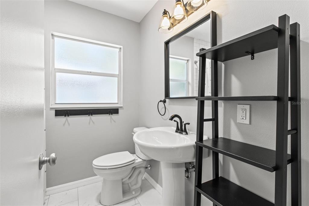 512 Richmond Street Dunedin, FL 34698 - Photo 14 of 37 a bathroom with a sink toilet and vanity